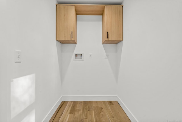 laundry area with cabinet space, hookup for a washing machine, baseboards, and light wood finished floors