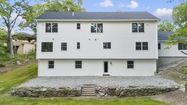 rear view of property featuring a yard