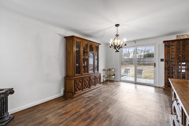 dining room with dark wood finished floors, baseboards, and an inviting chandelier