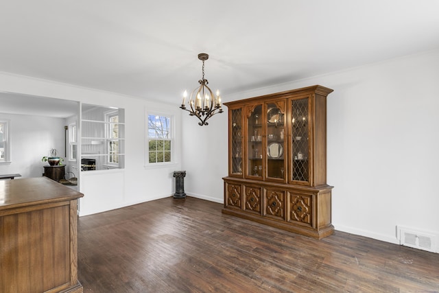 unfurnished dining area with dark wood-style floors, a fireplace, visible vents, and baseboards