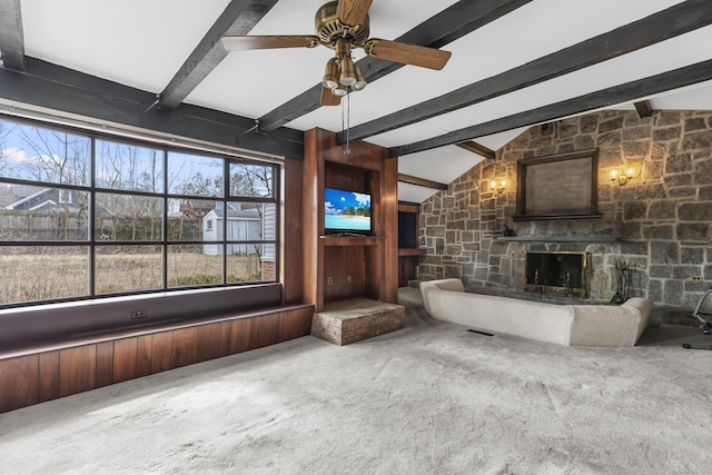 unfurnished living room with a ceiling fan, carpet, a fireplace, and lofted ceiling with beams