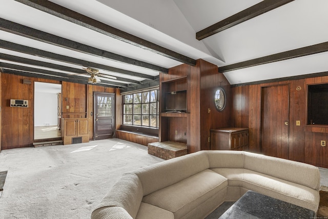 living area featuring lofted ceiling with beams, carpet floors, visible vents, and wooden walls