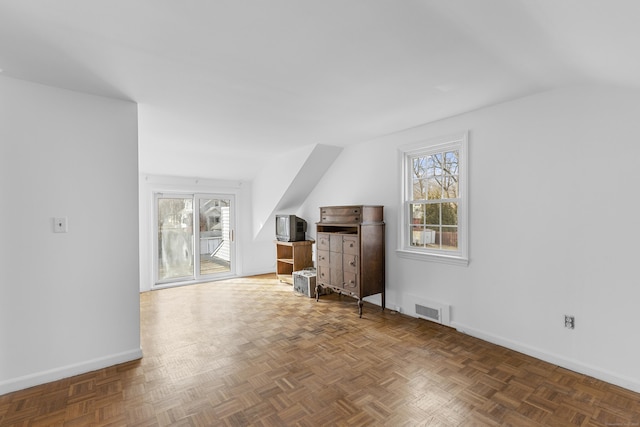 bonus room featuring lofted ceiling, visible vents, and baseboards