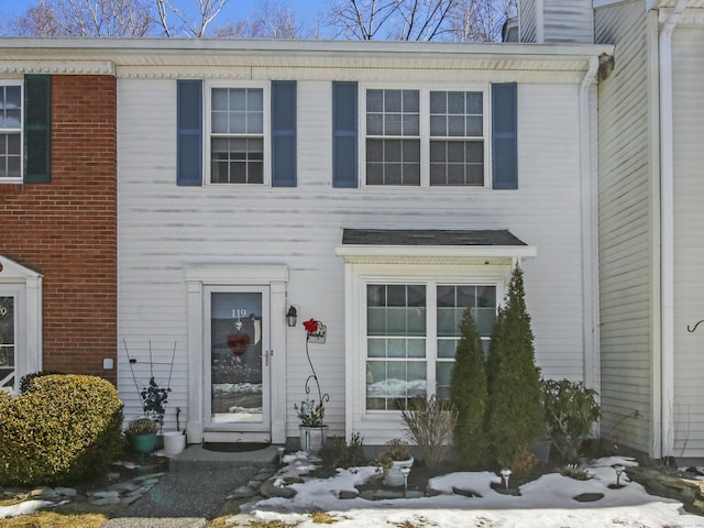 view of front of home with brick siding and a chimney