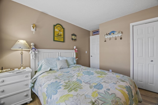 bedroom featuring a closet, a textured ceiling, and wood finished floors