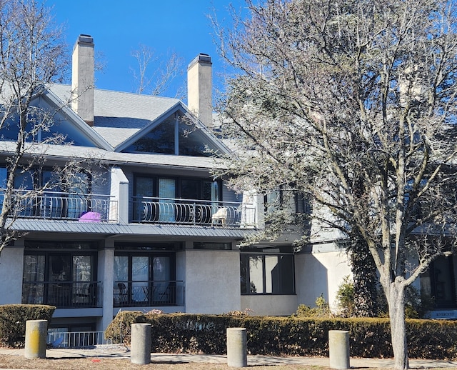 back of house featuring stucco siding and a balcony