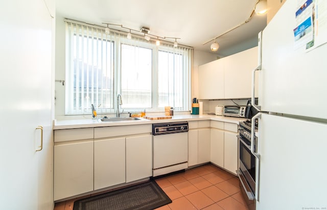 kitchen with white appliances, light tile patterned floors, a sink, light countertops, and white cabinets