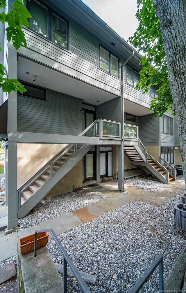 rear view of house featuring stairs and central AC