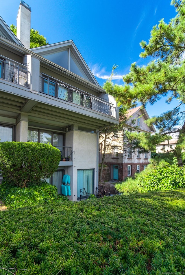 rear view of property featuring stucco siding and a balcony