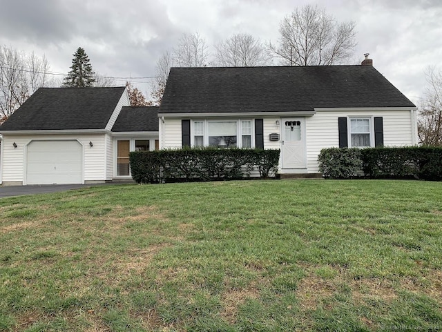 view of front of property featuring a garage, roof with shingles, a chimney, and a front yard