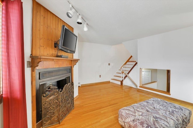 interior space with a fireplace, stairway, wood finished floors, and baseboards