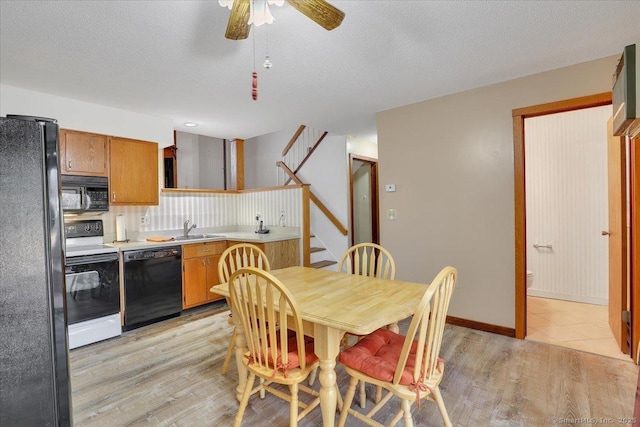 dining room featuring baseboards, stairway, a textured ceiling, and light wood-style floors