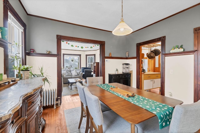 dining room with light wood-style floors and ornamental molding