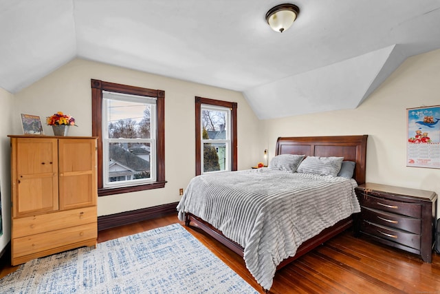 bedroom with lofted ceiling, wood finished floors, and baseboards