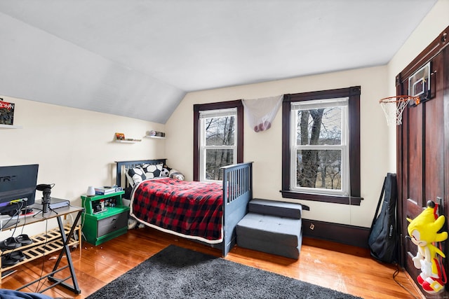 bedroom with vaulted ceiling and wood finished floors