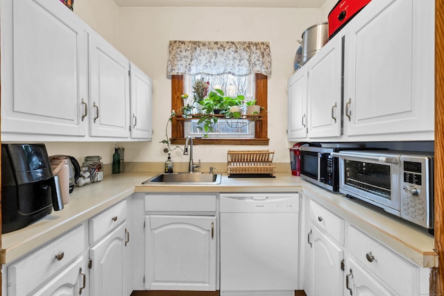 kitchen with a sink, white cabinetry, stainless steel microwave, and dishwasher