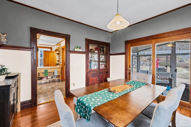 dining room featuring wood-type flooring and crown molding