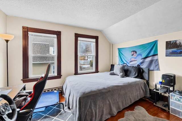 bedroom featuring vaulted ceiling, a textured ceiling, and wood finished floors