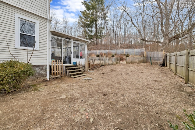 view of yard featuring a sunroom and a fenced backyard