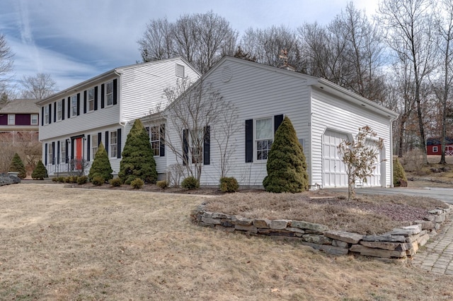 view of side of property featuring an attached garage and driveway