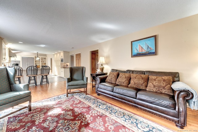 living area featuring light wood finished floors and a textured ceiling