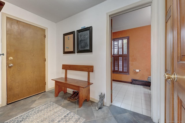 tiled foyer entrance featuring a baseboard radiator and baseboards