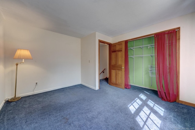 unfurnished bedroom with a closet, carpet flooring, and baseboards