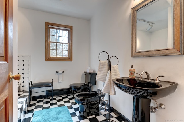 bathroom featuring baseboards, track lighting, and tile patterned floors