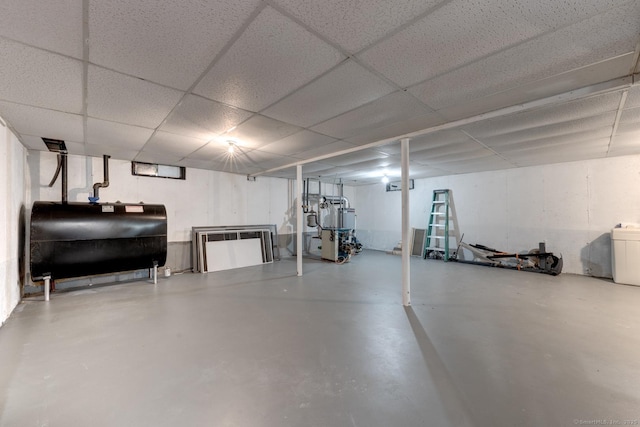 finished basement with a paneled ceiling and heating fuel