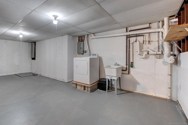 unfinished basement featuring washer / clothes dryer, electric panel, and a drop ceiling