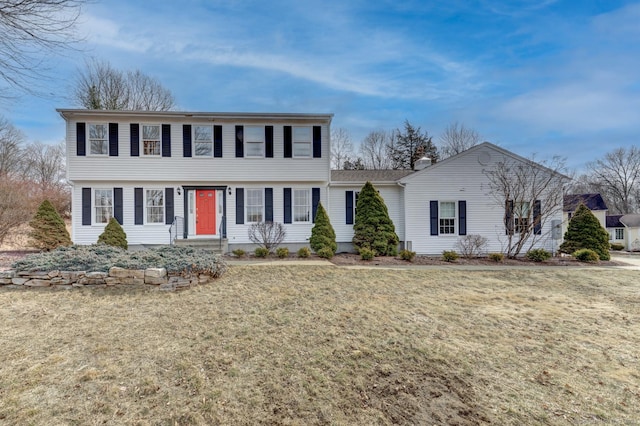 colonial inspired home featuring a front lawn