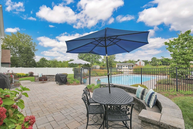 view of patio featuring a fire pit, a fenced in pool, area for grilling, fence, and outdoor dining space