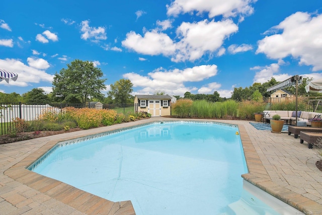 view of swimming pool with an outbuilding, a fenced backyard, an outdoor hangout area, a fenced in pool, and a patio area