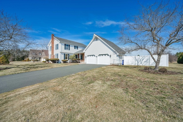 view of front of property with a front lawn, fence, a garage, and driveway