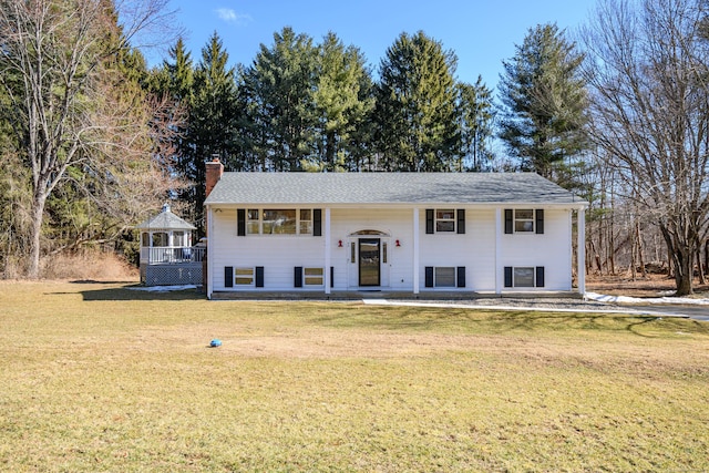 split foyer home featuring a gazebo, a chimney, and a front yard