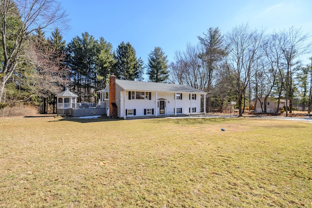 split foyer home with a chimney, a front lawn, and a gazebo