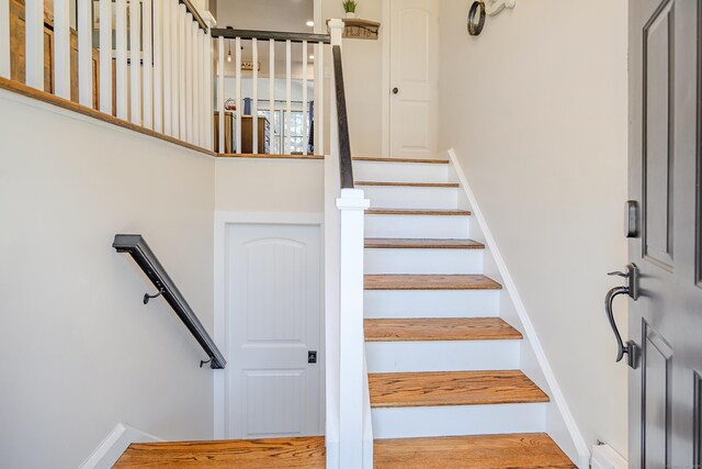 stairs featuring wood finished floors and baseboards