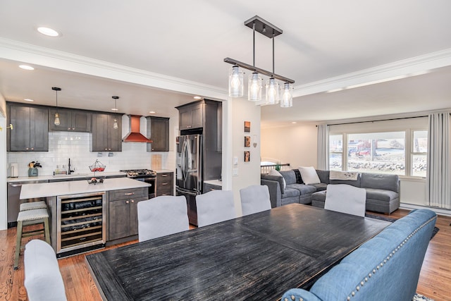 dining room featuring wine cooler, crown molding, and wood finished floors