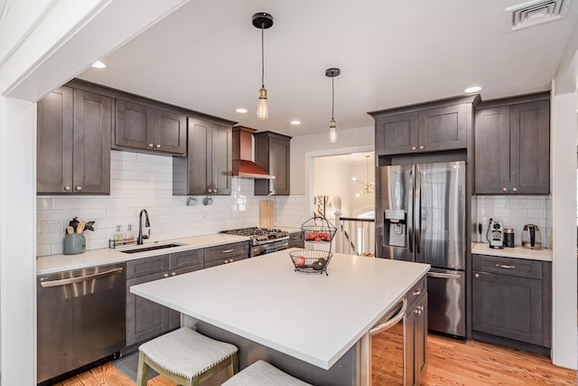 kitchen with wine cooler, visible vents, appliances with stainless steel finishes, a sink, and wall chimney range hood