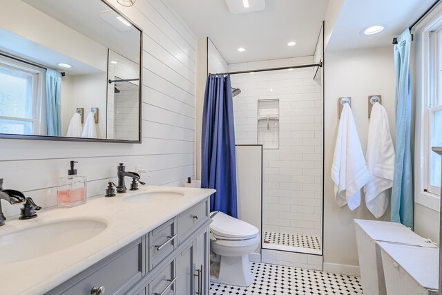 full bathroom with tiled shower, a sink, and toilet