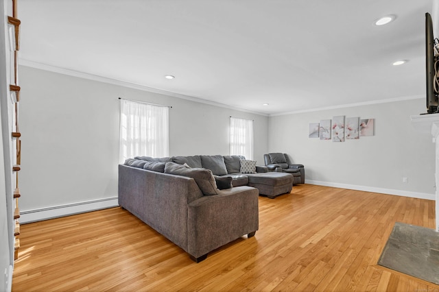 living room with baseboards, baseboard heating, crown molding, light wood-style floors, and a fireplace