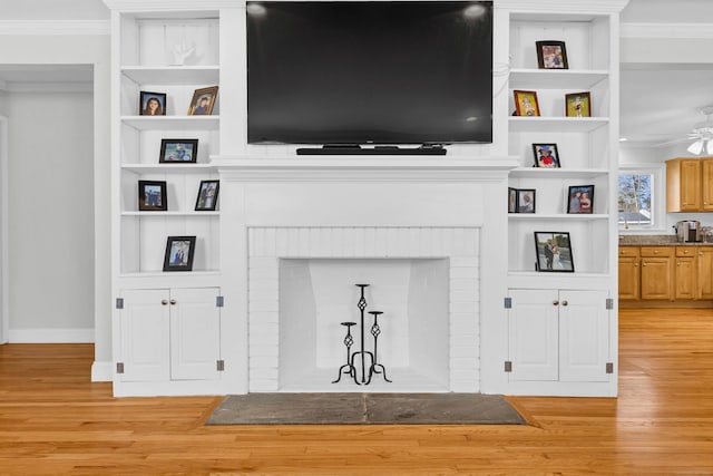 living area with ceiling fan, light wood-type flooring, a fireplace, and crown molding