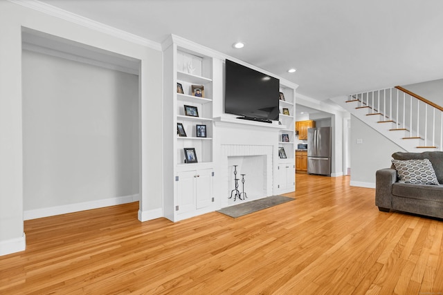 living room with baseboards, stairway, crown molding, light wood-style floors, and a fireplace