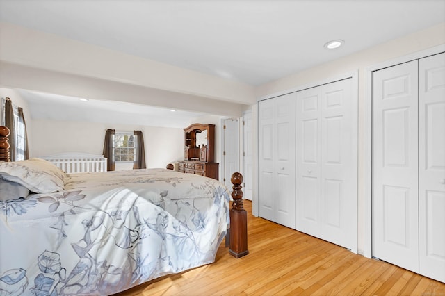 bedroom featuring light wood-type flooring, multiple closets, and recessed lighting