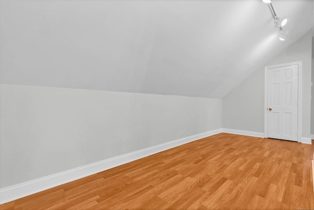 bonus room featuring lofted ceiling, light wood finished floors, and baseboards