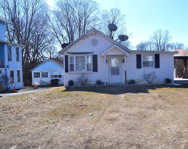 view of front facade featuring a garage, a front yard, and an outbuilding