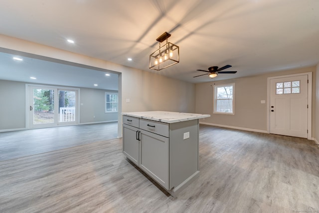 kitchen featuring light wood finished floors, open floor plan, and gray cabinetry