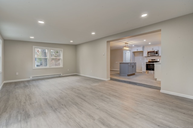 unfurnished living room with a baseboard heating unit, light wood-type flooring, baseboards, and recessed lighting