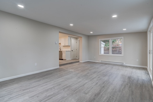 unfurnished living room with light wood-type flooring, baseboards, baseboard heating, and recessed lighting