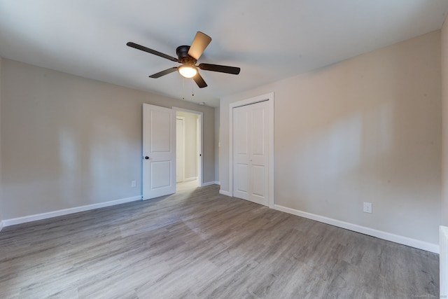 unfurnished room with ceiling fan, wood finished floors, and baseboards